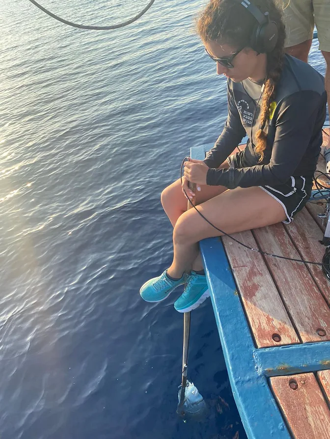 Yaly Mevorach doing passive acoustic monitoring from a boat
